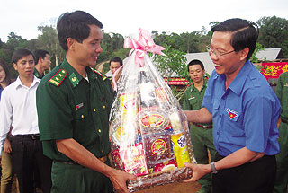 Anh Phan Văn Mãi (phải) tặng quà tết cho đại diện Đồn biên phòng 785