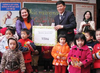 Chị Nguyễn Thị Hà (bìa trái) tặng quà Tết cho các em Làng trẻ SOS Hà Nội