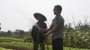 Kỹ sư Hồ Công Lượng hướng dẫn kỹ thuật trồng, tưới rau cho một nông dân  - Ảnh: Đoàn Cường